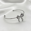 Bracelet nœud argenté sur fond soie blanc