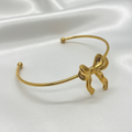 Bracelet nœud doré sur fond soie blanc