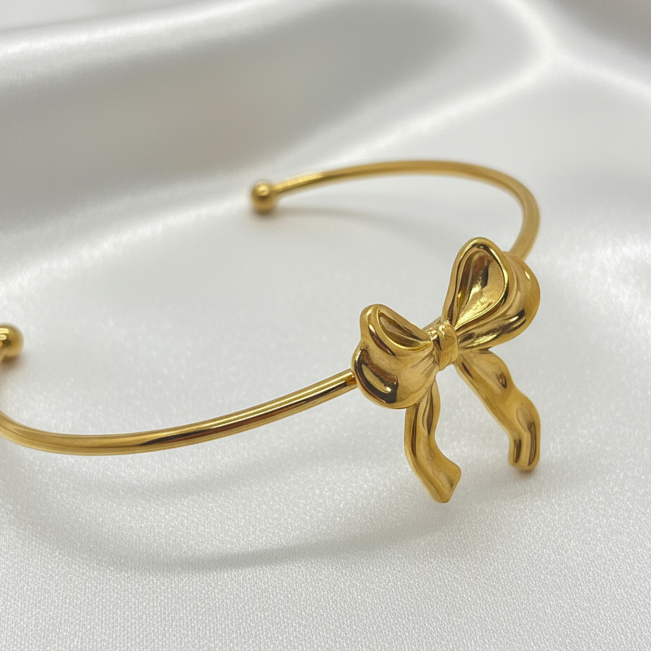 Bracelet nœud doré zoom sur fond soie blanc