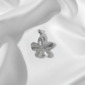 Pendentif fleur argentée sur fond soie blanche