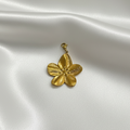 Pendentif fleur dorée sur fond soie blanche