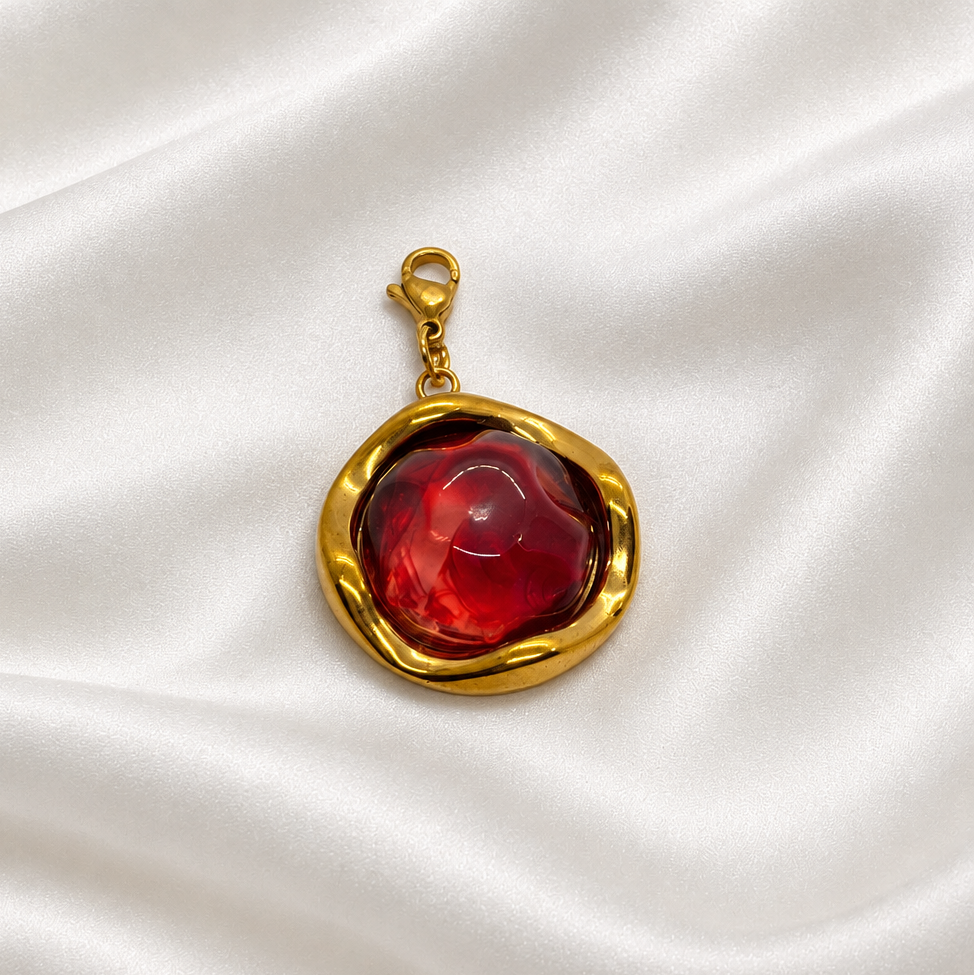 Pendentif rouge et doré sur soie blanche